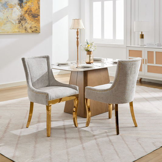 Pair of beige chenille dining chairs with gold-plated legs and rivet trim, designed by Anthony & Home, set of 2.