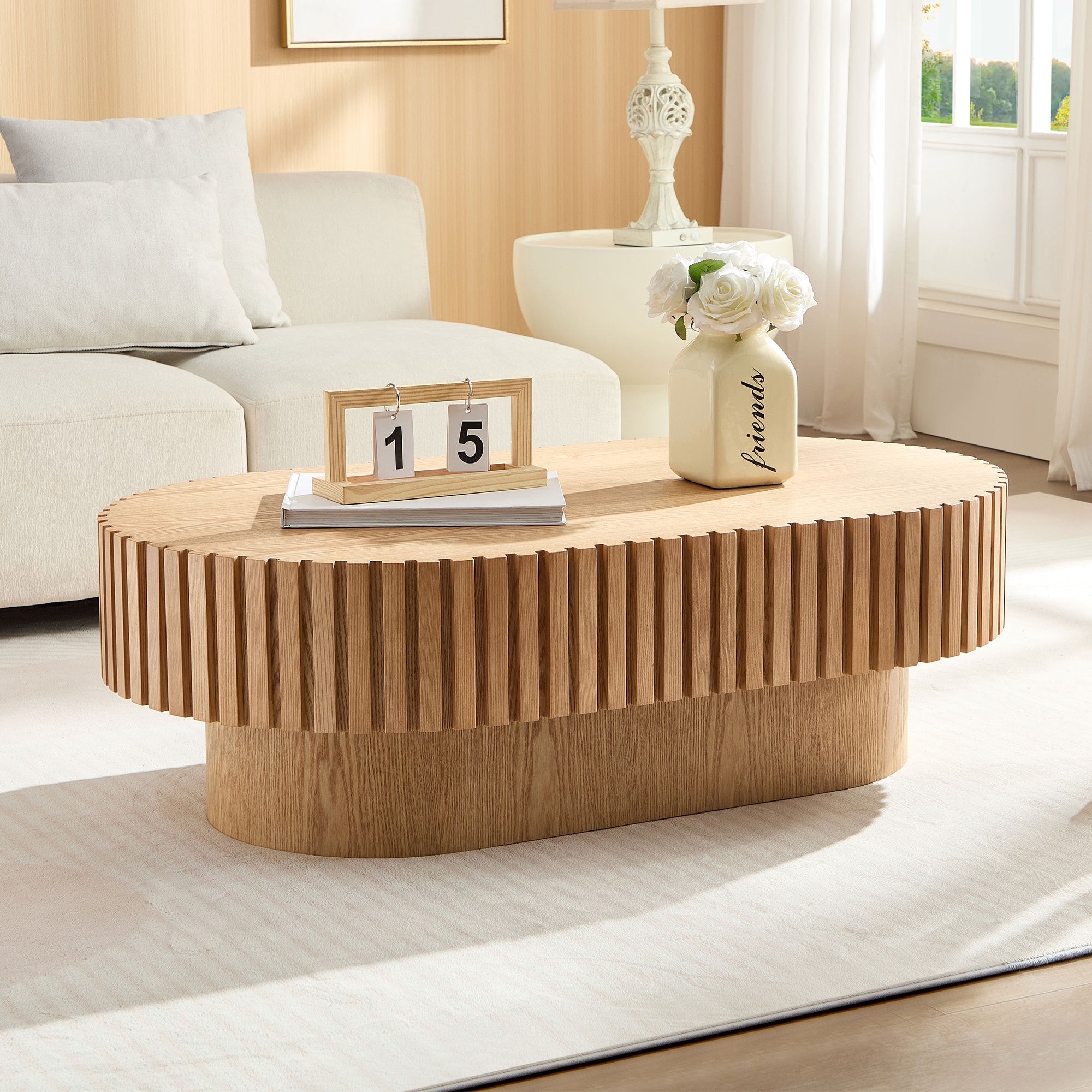 Oval drum coffee table in ash finish with 43.7-inch diameter from Anthony & Home, showcasing its smooth wooden surface and rounded design.