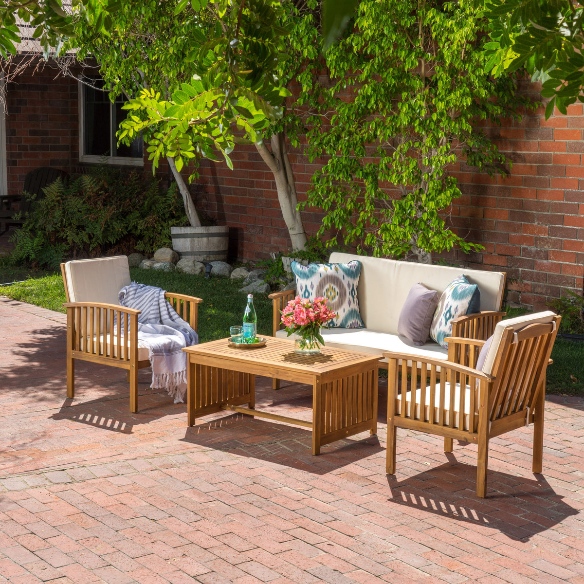 Anthony & Home acacia wood outdoor chat set with water-resistant cushions, featuring a cozy seating arrangement with cushions and a table.