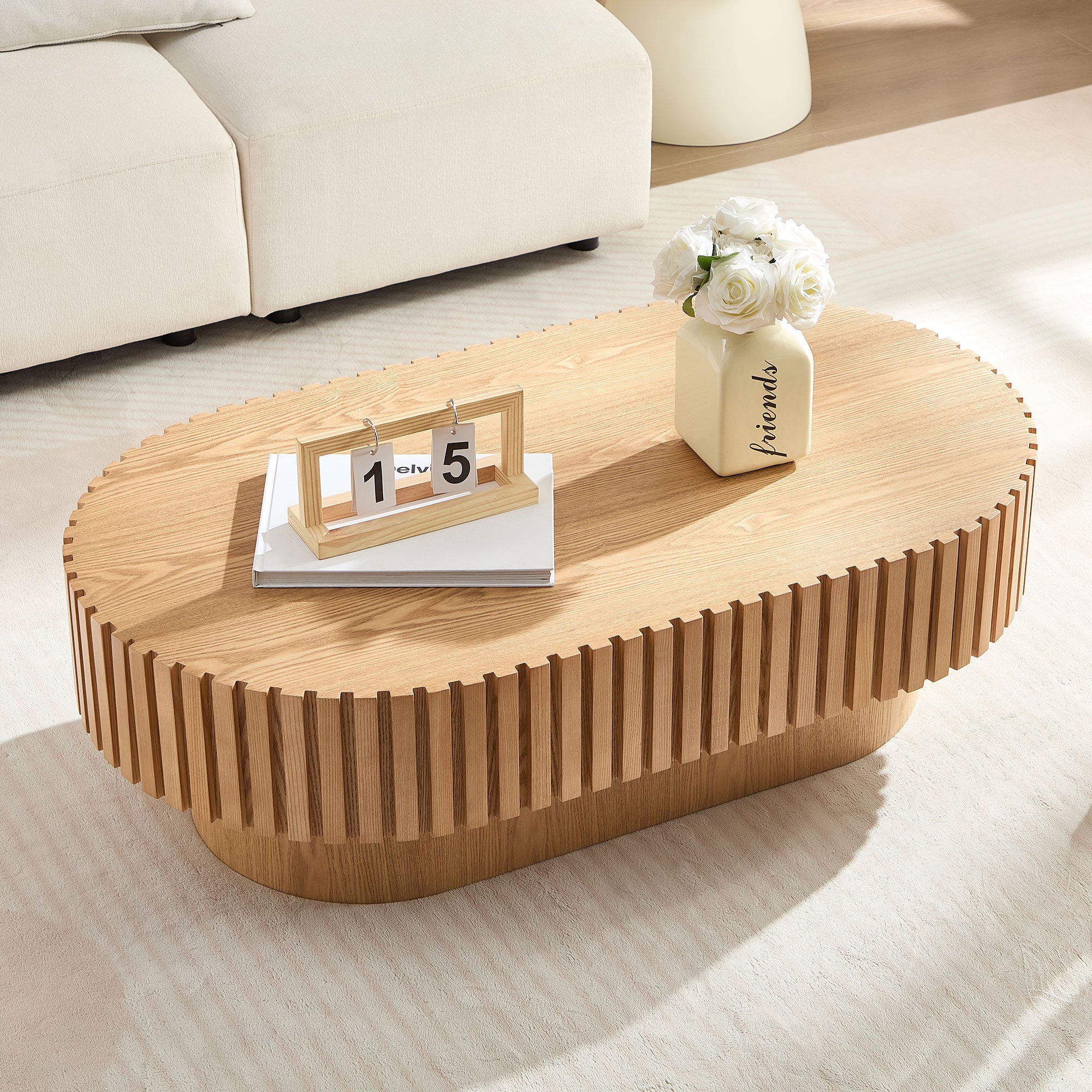 Oval drum coffee table in ash finish by Anthony & Home, 43.7 inches wide, with a smooth, modern wood surface.