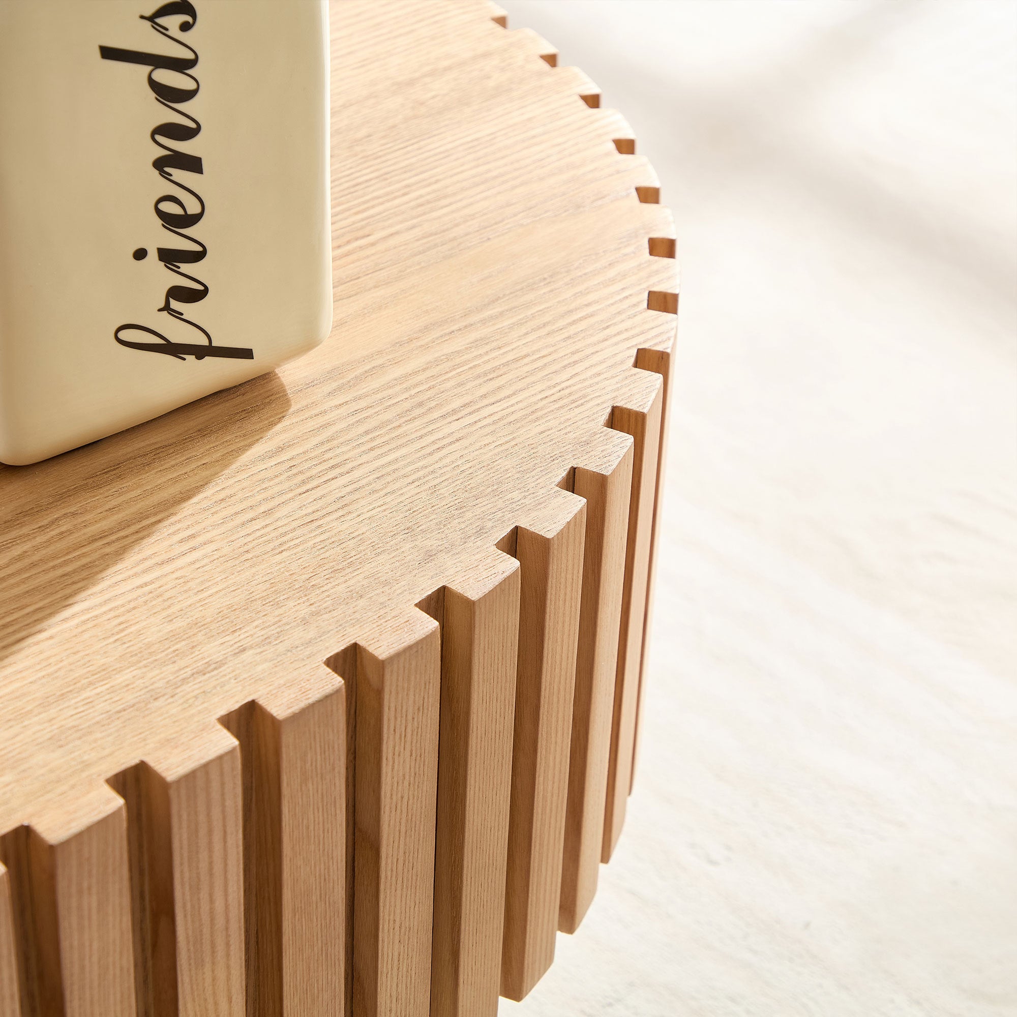 Oval drum-shaped coffee table in ash finish with 43.7-inch diameter, by Anthony & Home, shown from a top view.