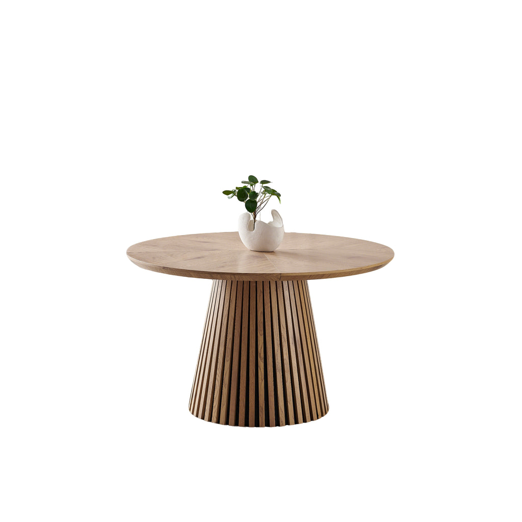 Round solid wood dining table from Anthony & Home's Atelier Collection, featuring a smooth polished surface and sturdy wooden legs.