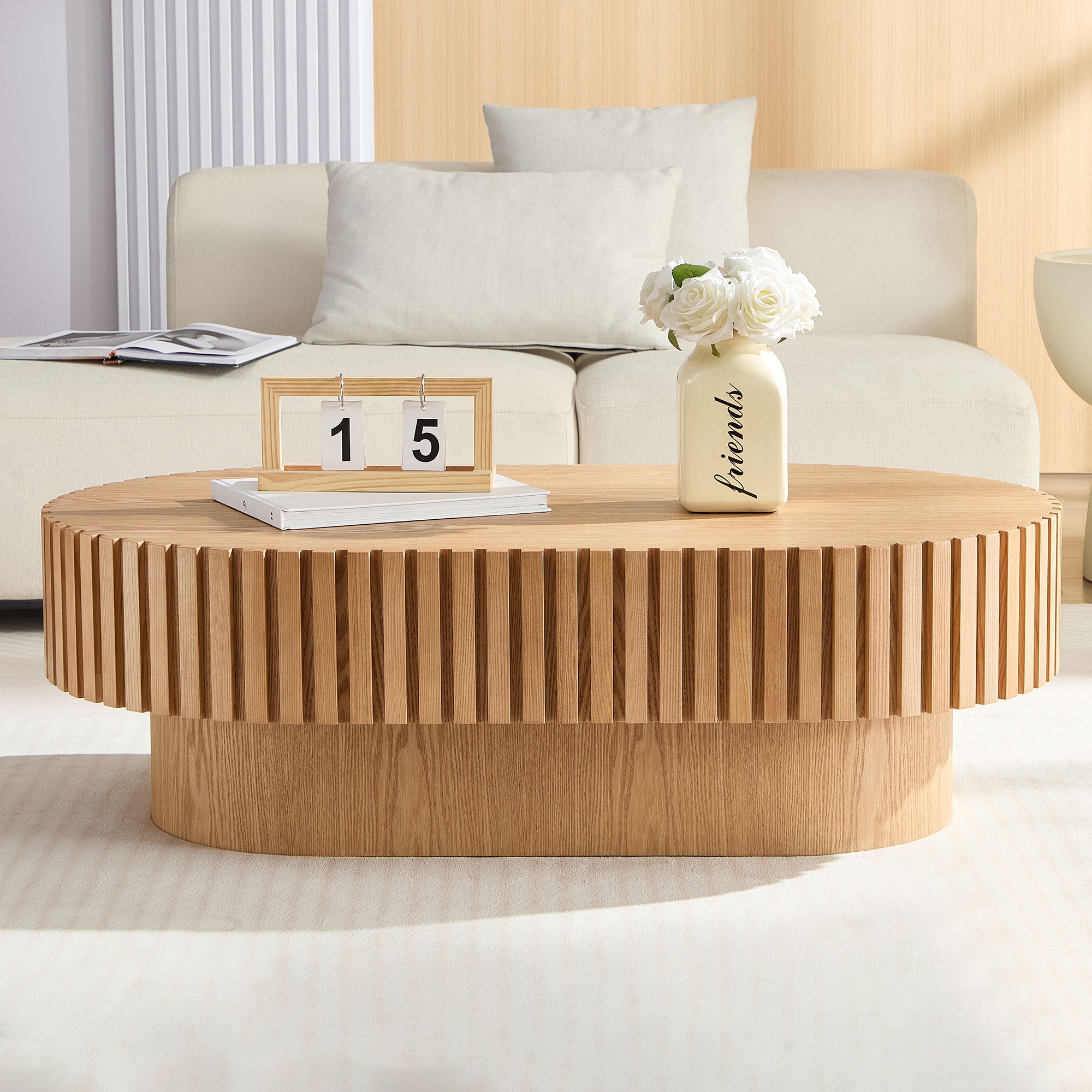Oval drum coffee table in ash finish with a smooth surface and rounded edges, 43.7 inches long, by Anthony & Home.