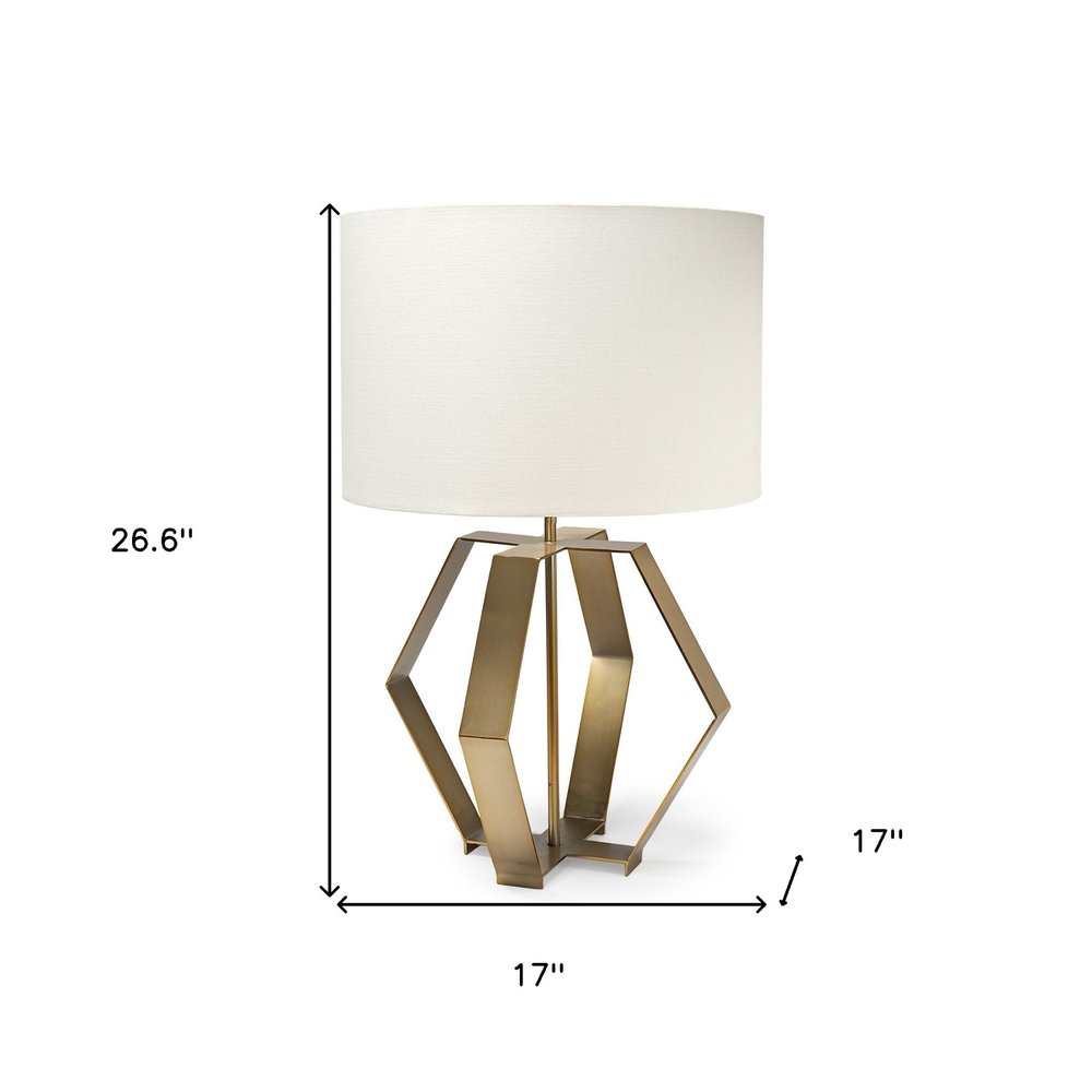 Gold geometric design table lamp by HomeRoots featuring a modern, angular base and a fabric lampshade on a wooden table