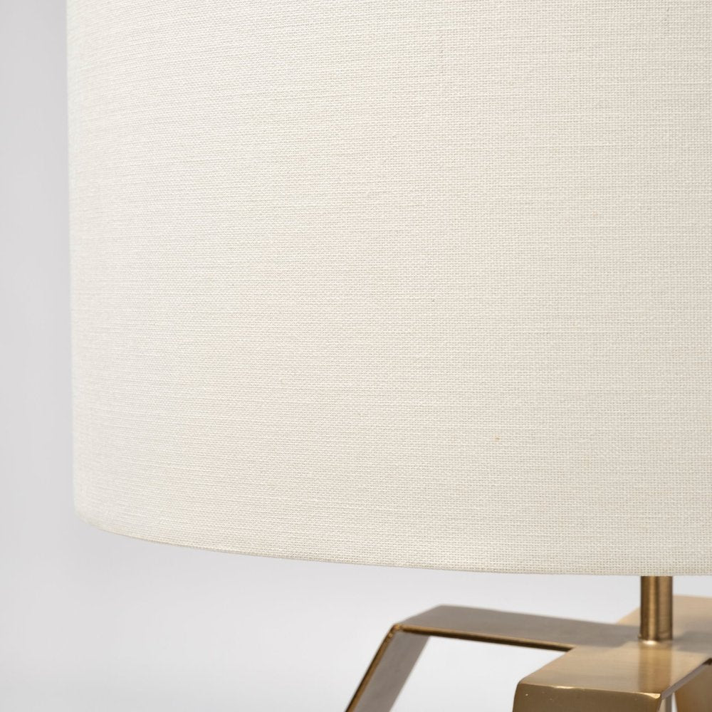 Gold geometric design table lamp by HomeRoots with a sleek base and modern geometric shade on a wooden table.