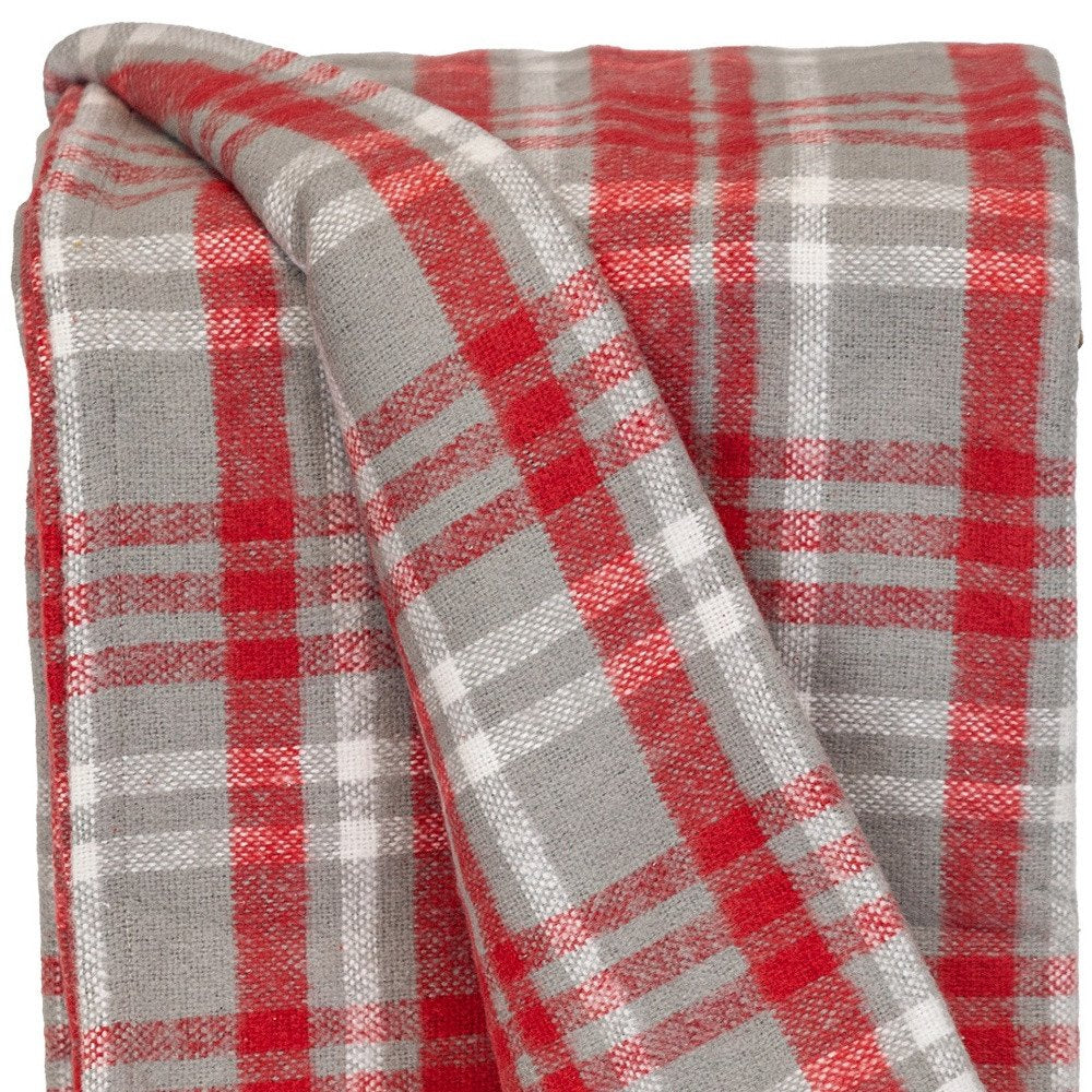 Red woven cotton plaid throw blanket with fringed edges, styled on a cozy sofa for home decor.