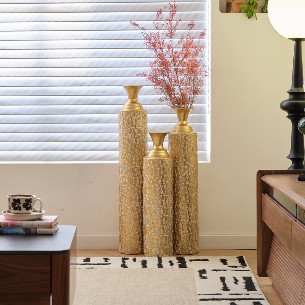 Set of three Heritage Collection gold distressed metal vases with growing vine pattern by Anthony & Home, ideal for living room decor.