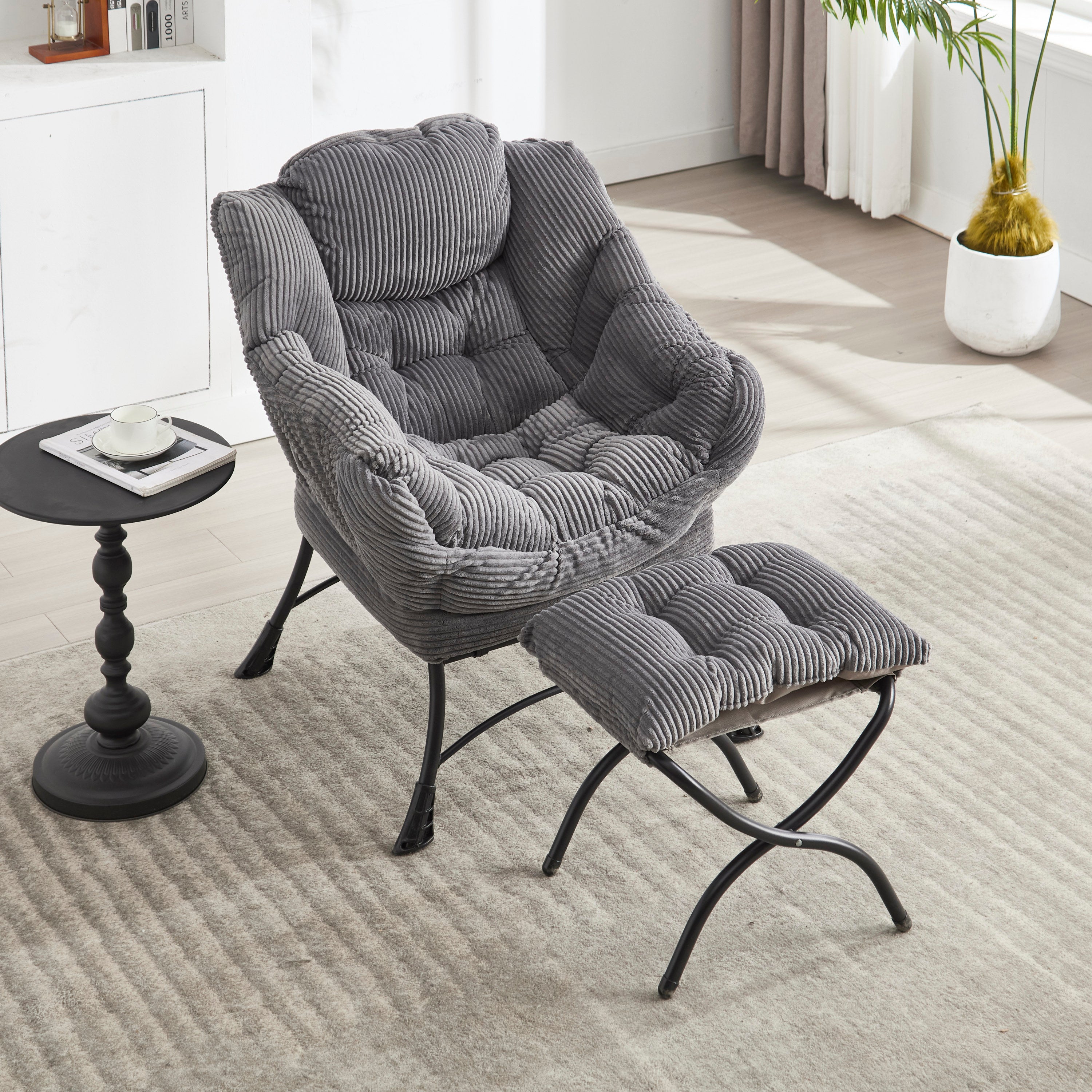 Grey upholstered lounge chair with matching ottoman and armrests, modern design from Anthony & Home.