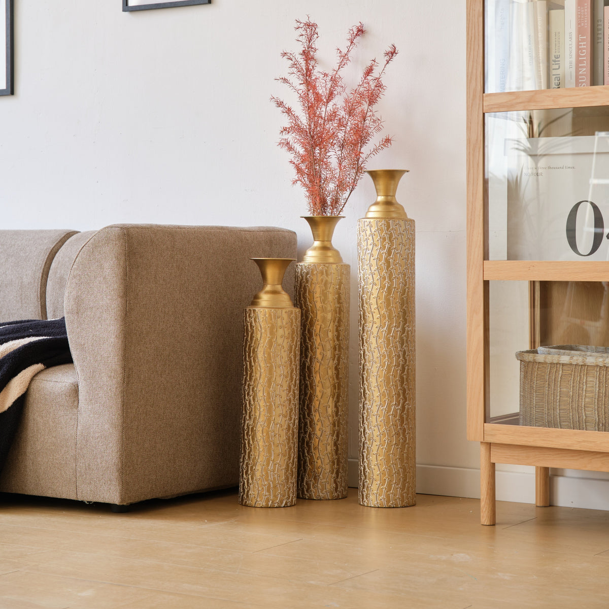 Set of three Heritage Collection Anthony & Home gold distressed metal vases with growing vine pattern for living room decor.