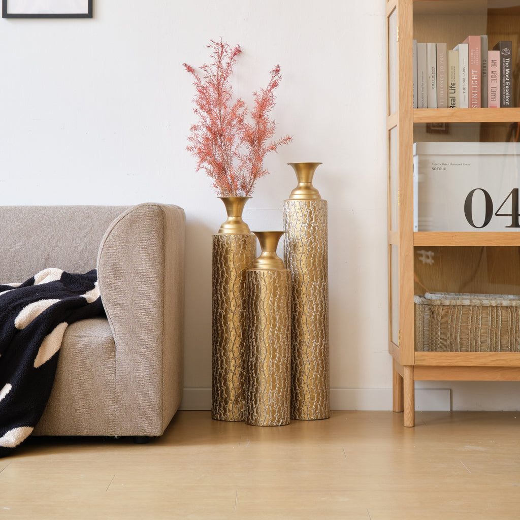 Set of three Anthony & Home Heritage Collection gold distressed metal vases with vine pattern for living room decor.