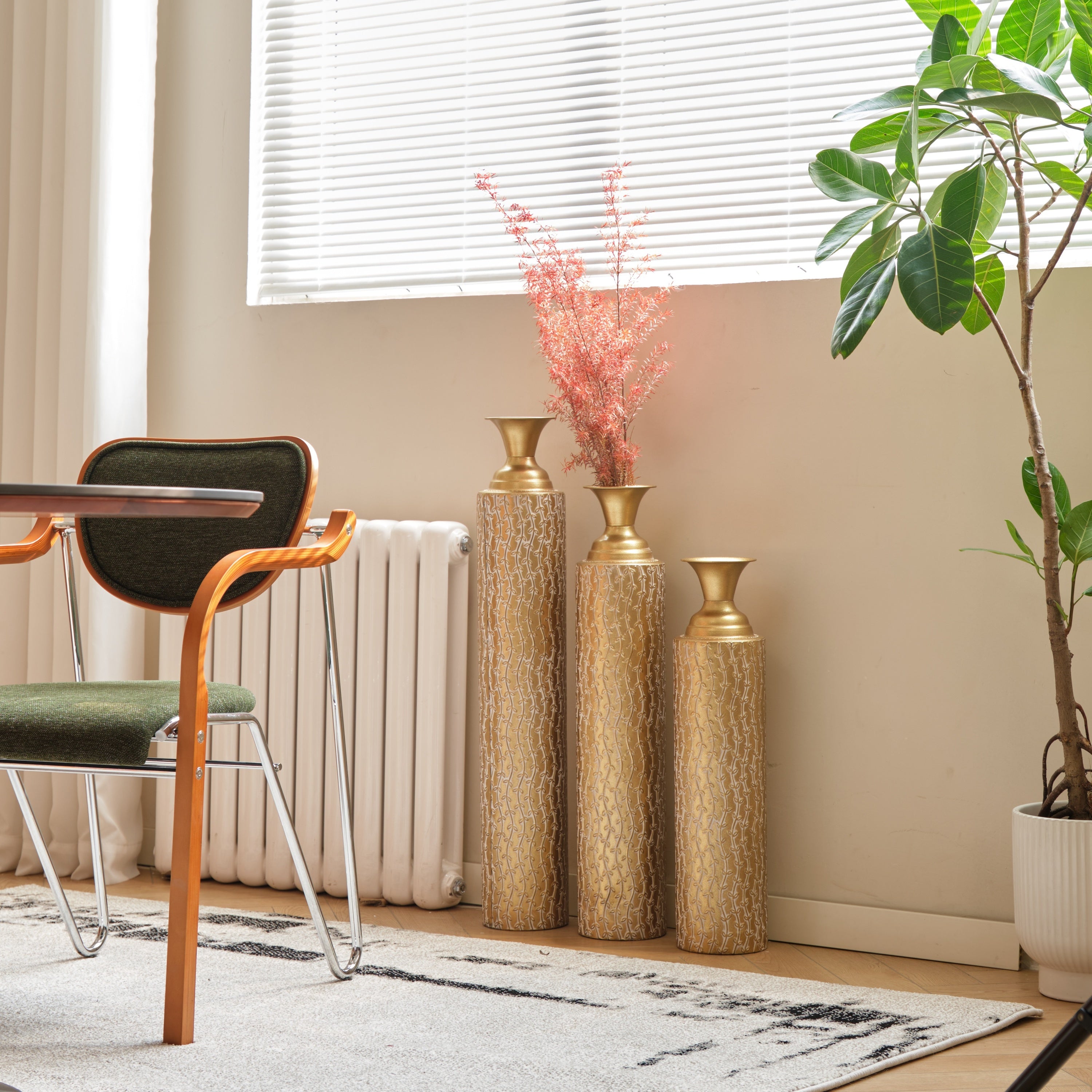 Set of three Anthony & Home Heritage Collection gold distressed metal vases with growing vine pattern, perfect for living room decor.