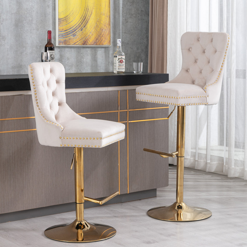 Pair of AA Furniture beige velvet bar stools by Anthony & Home with tufted seats and copper nailhead trim, shown from a side view.