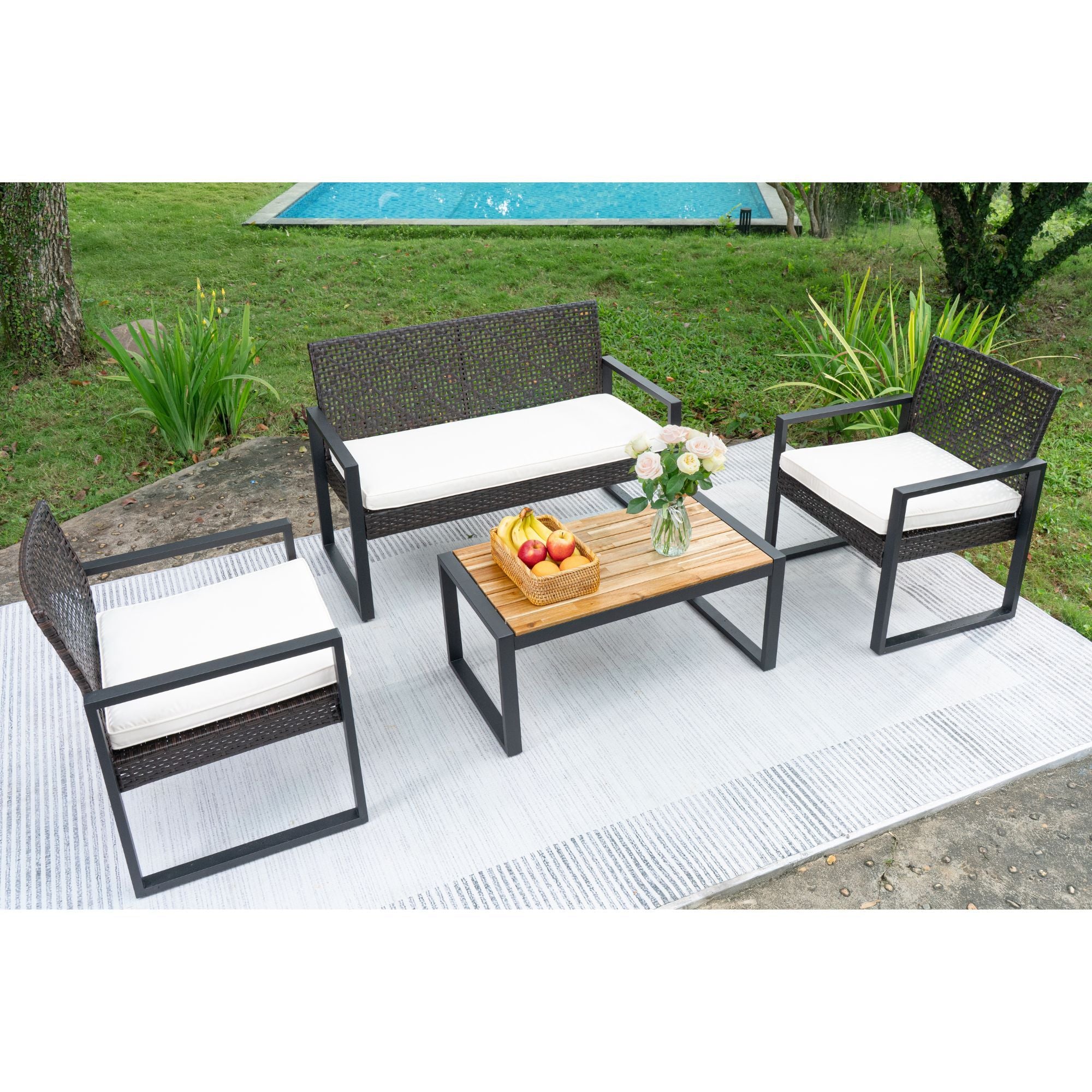 Acacia wood patio table with wicker frame and beige cushions, outdoor dining set by Anthony & Home in a garden setting.