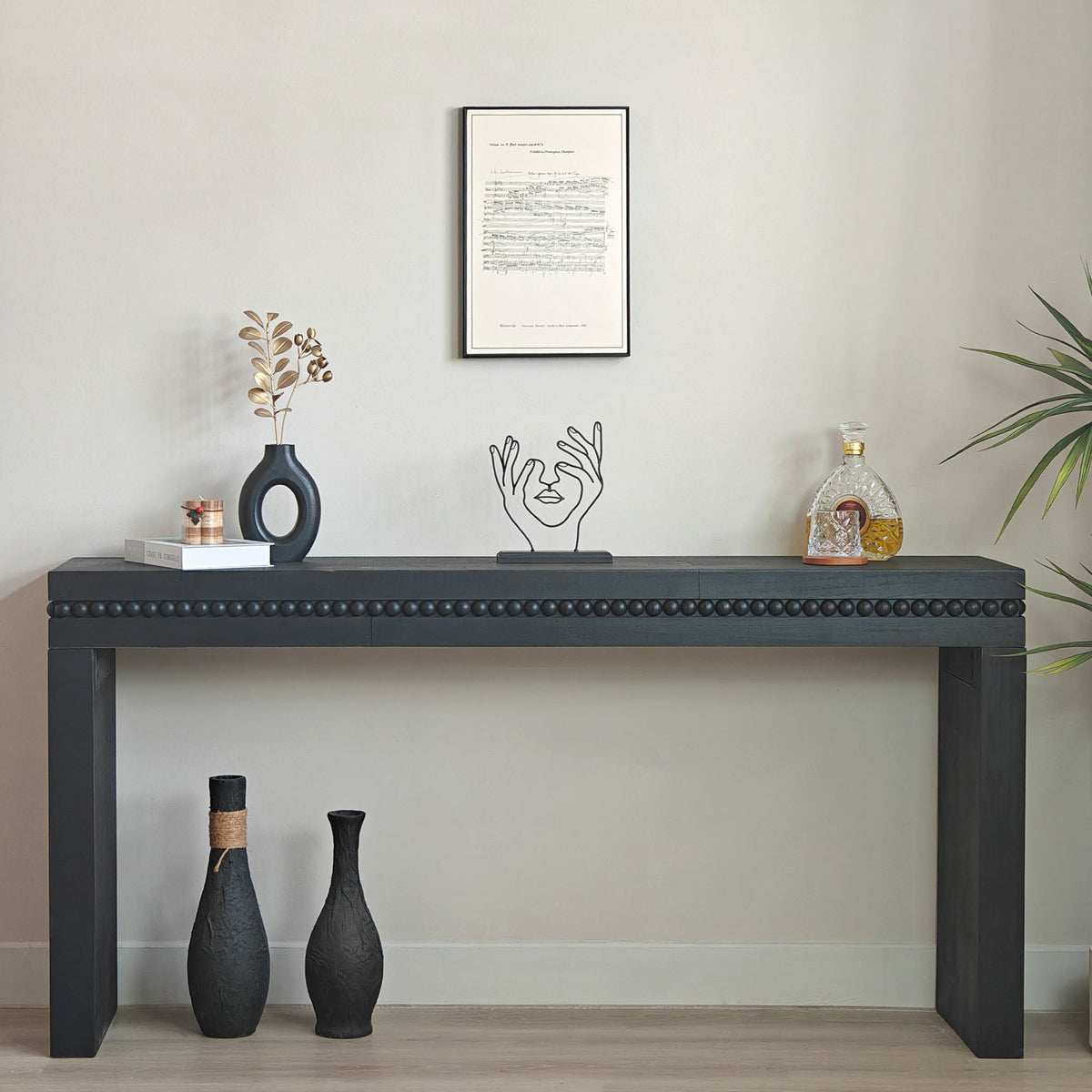 Antique black console table from the Artisan Collection by Anthony & Home showing a sleek wooden surface and elegant design.