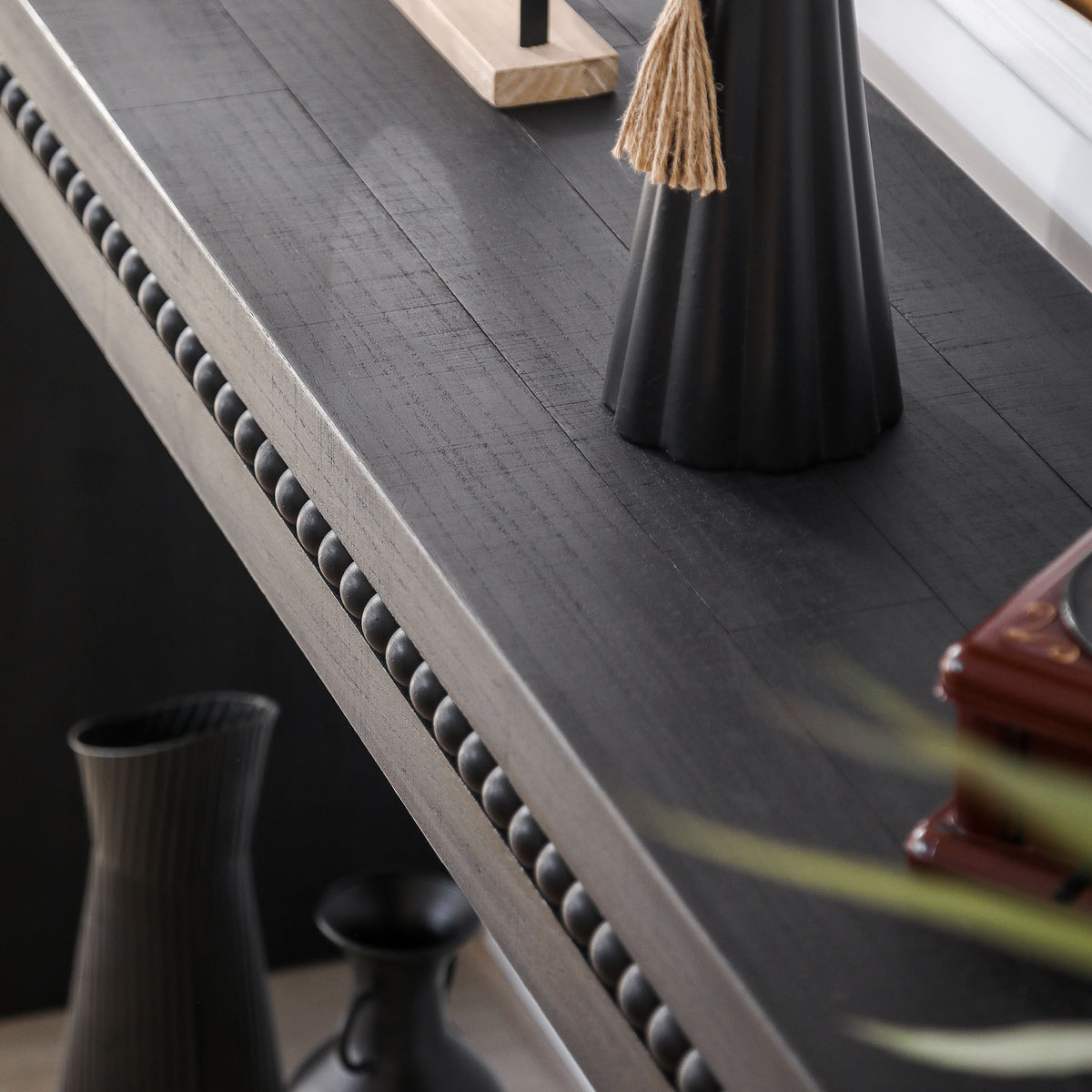 Antique black console table from Anthony & Home Artisan Collection with elegant carved details and sturdy wooden construction.