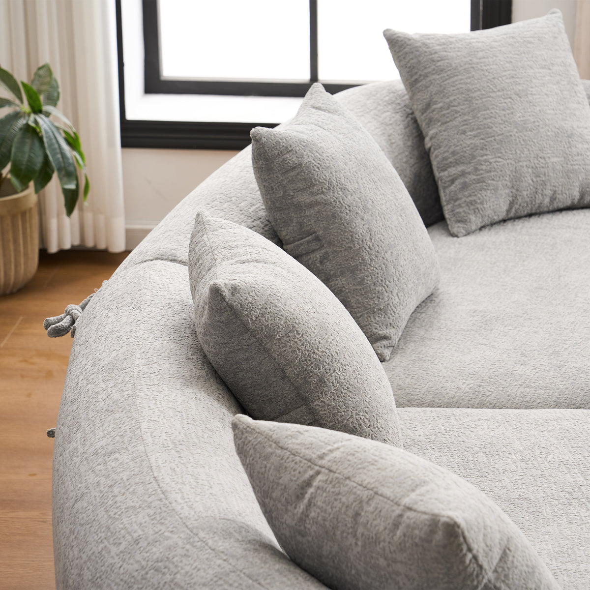 Grey curved modular sofa in chenille fabric from Anthony & Home's exclusive edition, showcasing plush seating and modern design.