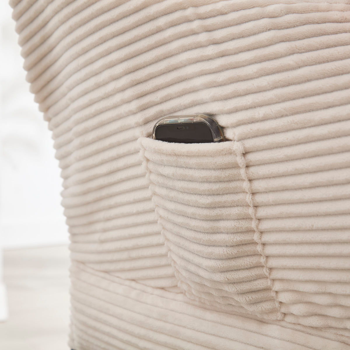Ivory upholstered lounge chair with matching ottoman and side pocket, modern reading nook accent by Anthony & Home.
