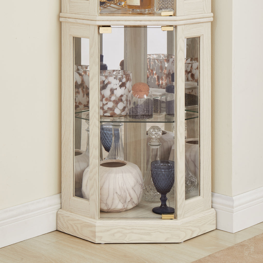 White lacquer lighted corner curio cabinet by Anthony & Home with glass doors and display shelves.