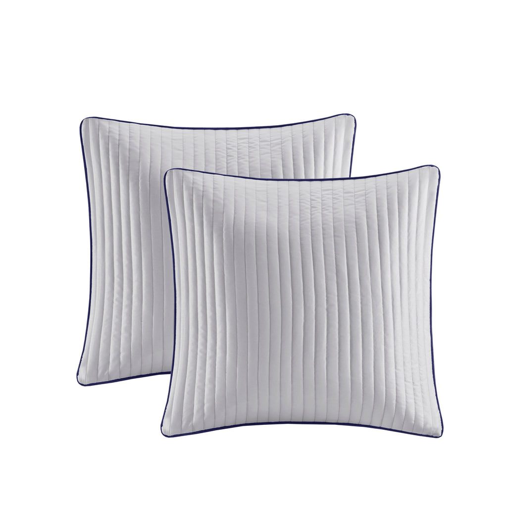 Navy jacquard cotton 12-piece Atelier Comforter Set by Anthony & Home with decorative pillows on a bed.
