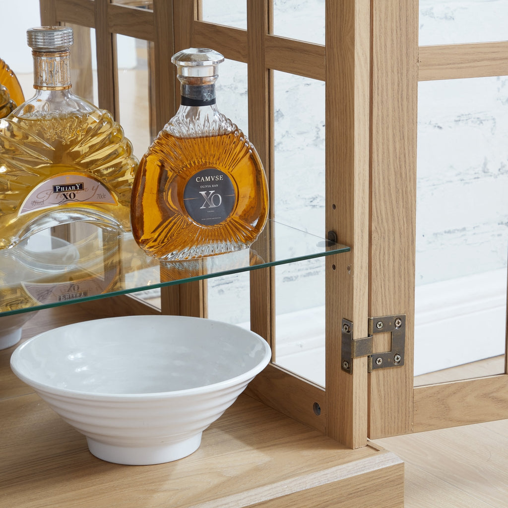 Oak curio cabinet with glass doors by Anthony & Home, showcasing a elegant storage display with intricate wood details.