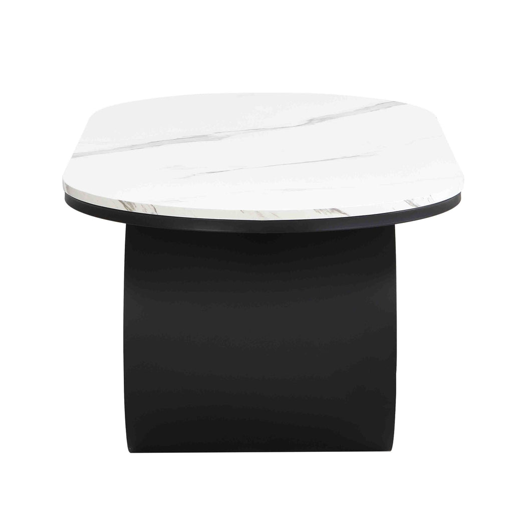 Oval coffee table with faux marble top and black metal frame in a modern studio setting, by Anthony & Home.