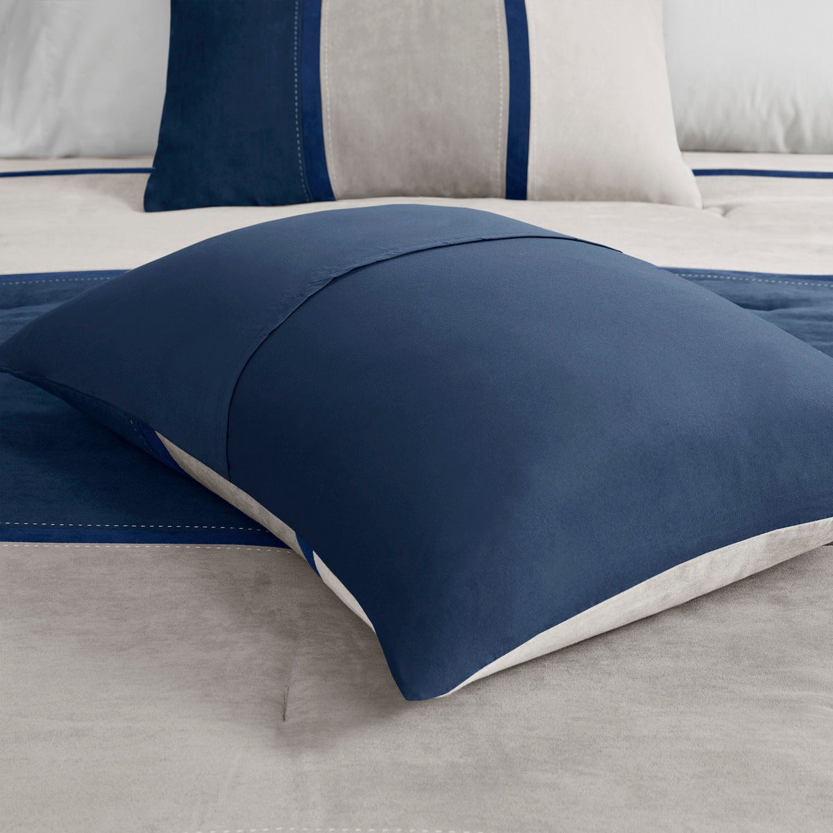 Blue Anthony & Home Palisades faux suede 7-piece comforter set with matching pillow shams and sheets on a bed.
