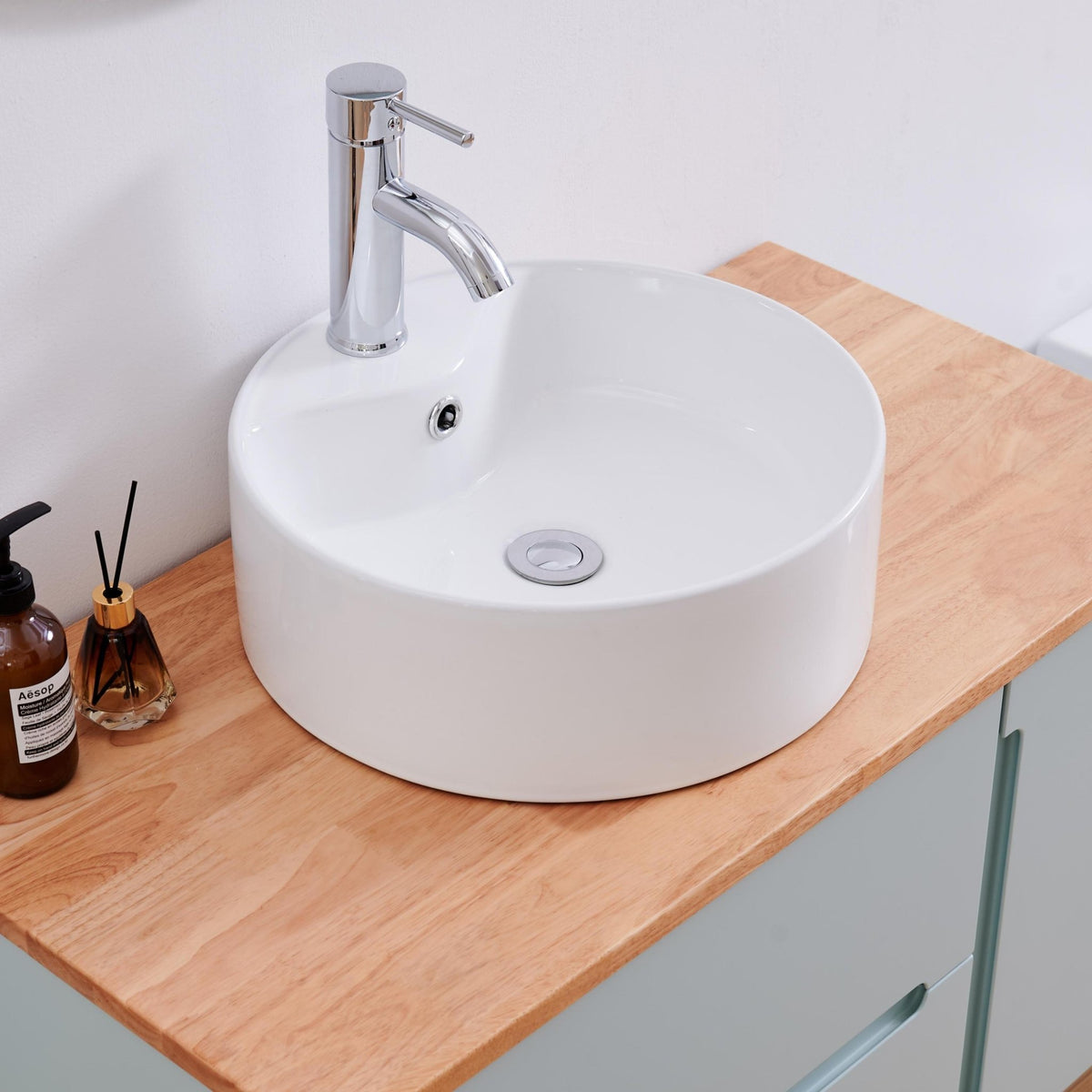 Round ceramic vessel sink in glossy white by Anthony & Home, designed for bathroom use, with a smooth, shiny surface.