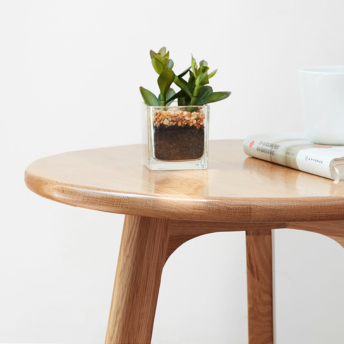 Solid oak round end table from Anthony & Home's Signature Collection, featuring a smooth wooden surface and sturdy legs.