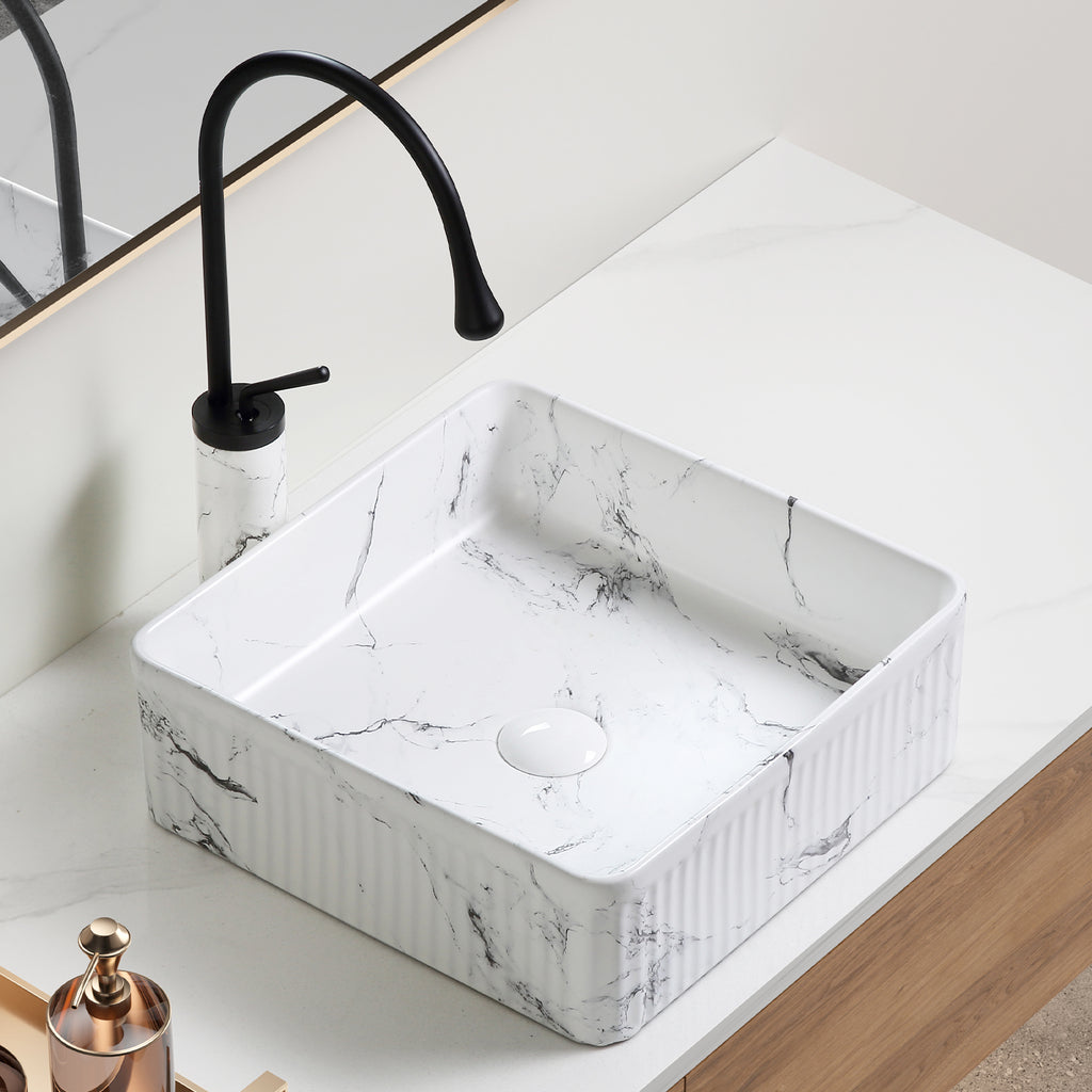 Square marble vessel sink with black and white marble finish, 15-inch size, by Anthony & Home, shown with water and bathroom setting