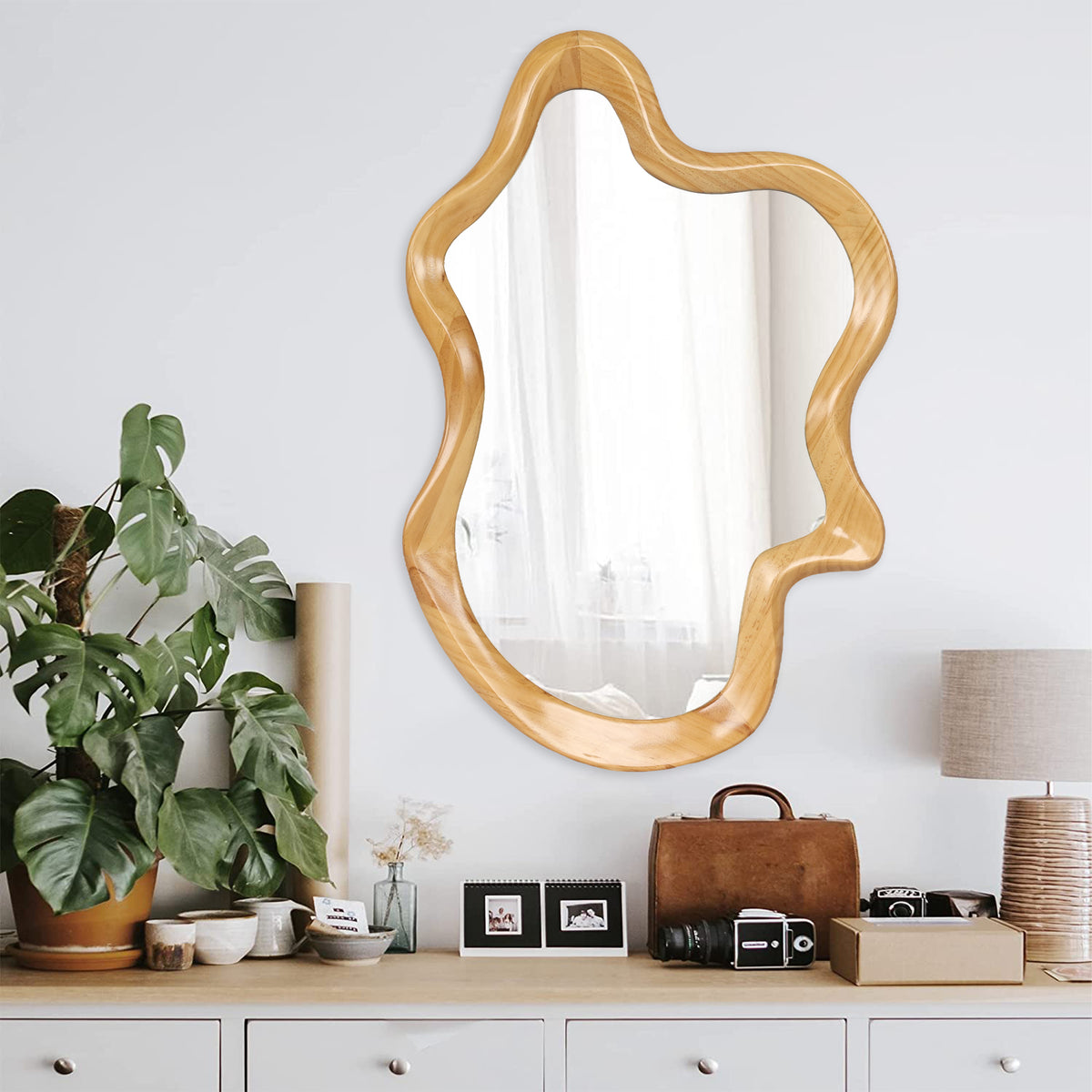 Wall mirror with natural wood frame and irregular silhouette from Anthony & Home, showcasing a stylish, modern design.