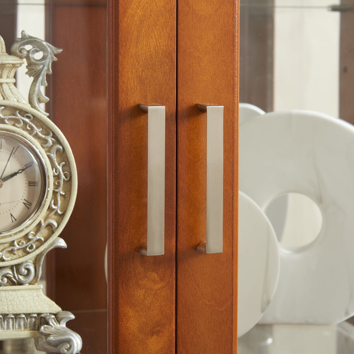 Walnut finish lighted curio cabinet with mirrored back and glass shelves, showcasing collectibles and decorative display space.