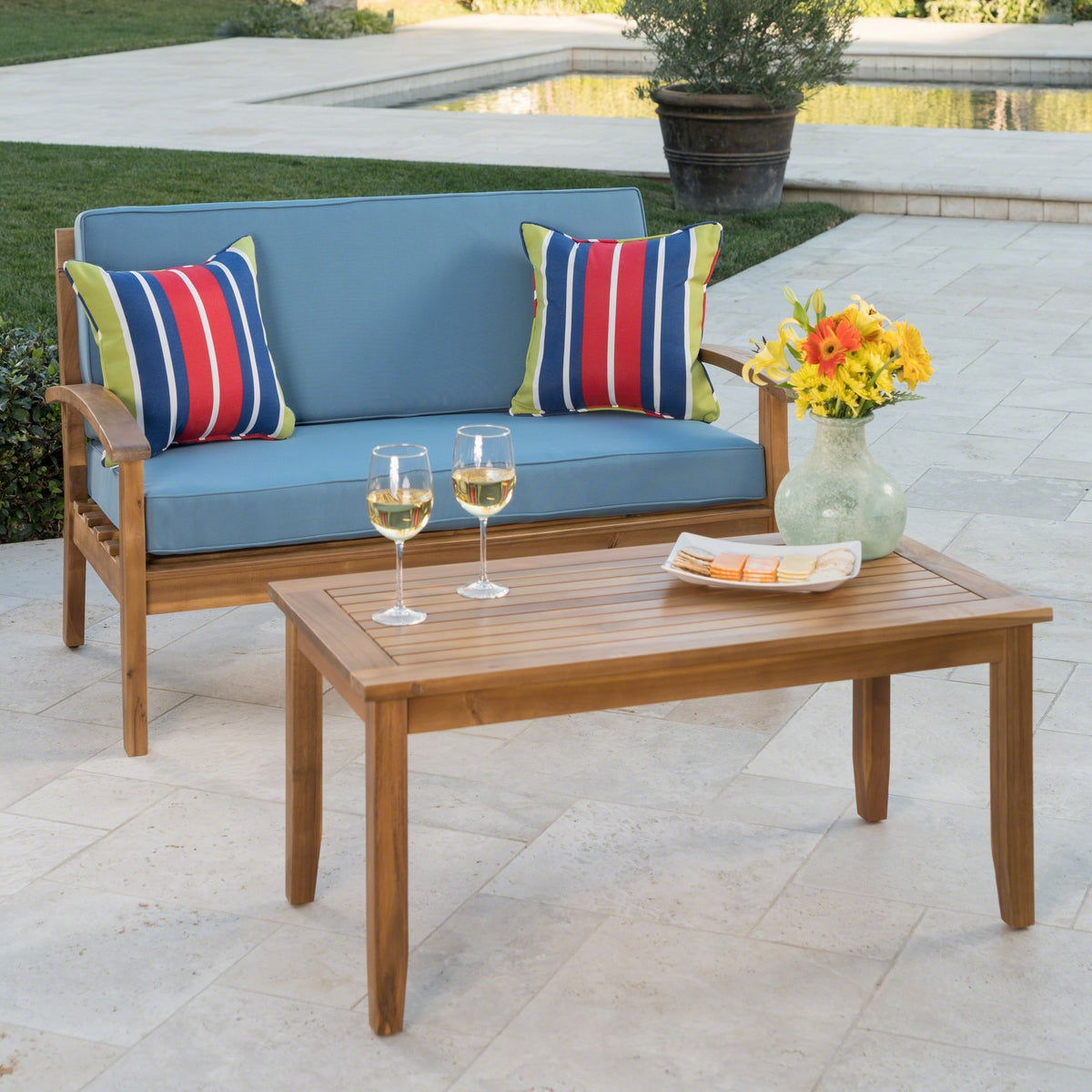 Anthony & Home teak outdoor chat set with loveseat and coffee table from the Atelier Collection, featuring a handcrafted finish.