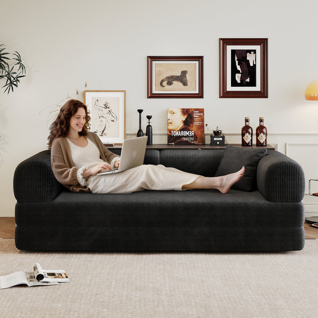 Black corduroy convertible sofa bed from Anthony & Home's Atelier Collection, showing the sofa in its seated and bed positions.