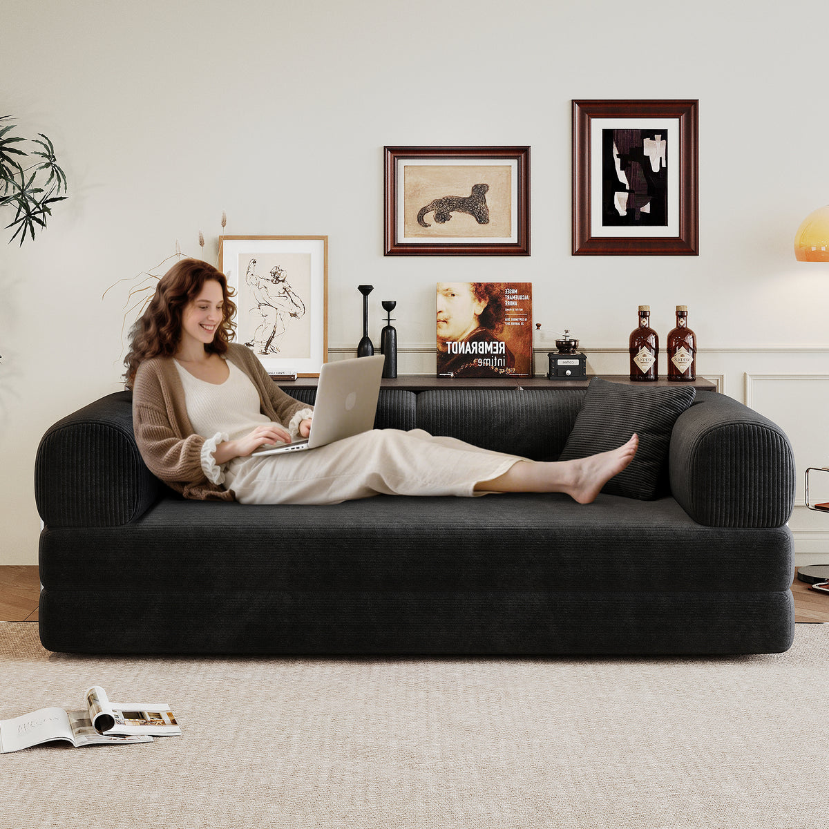 Black corduroy convertible sofa bed from Anthony & Home's Atelier Collection, showing the sofa in its seated and bed positions.