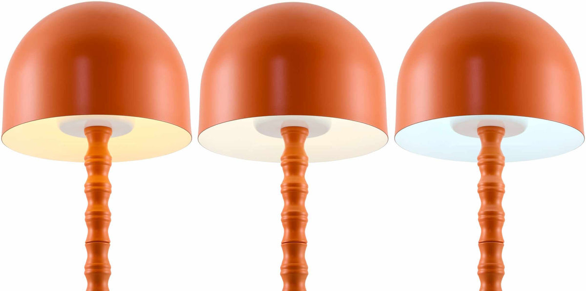 Orange Boutique Rugs Magdagachi table lamp with a sleek, modern design and detailed ceramic base, illuminated on a dark background.